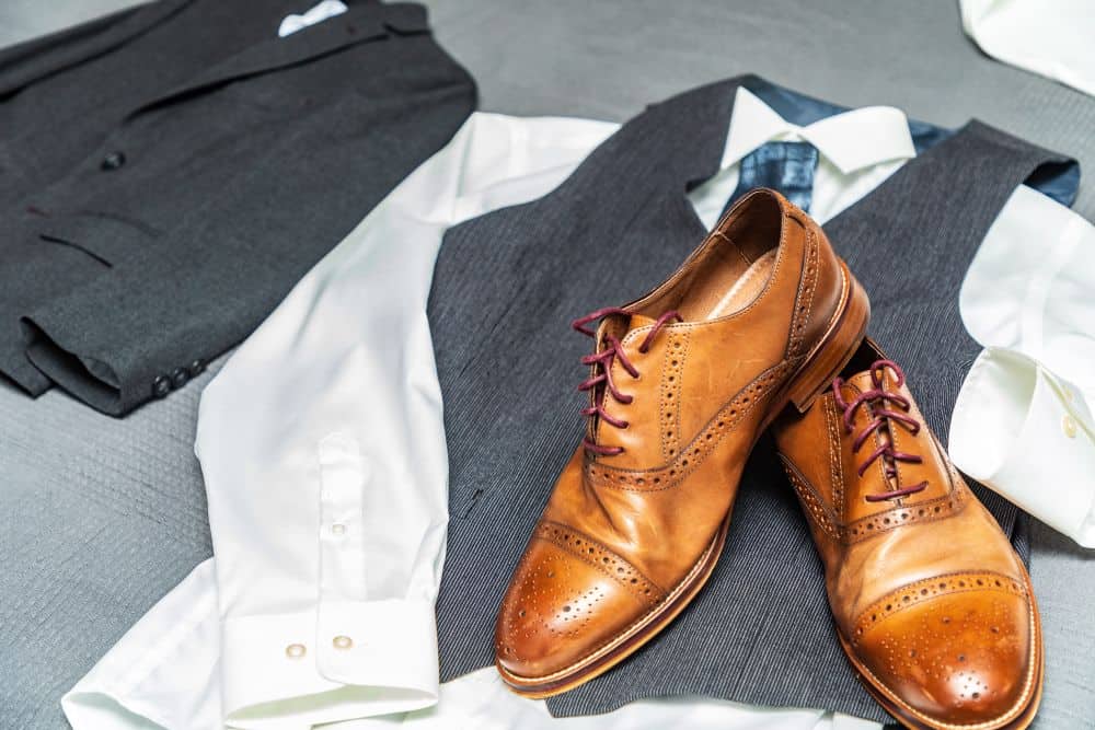 A man’s suit outfit laid out with formal shoes to match