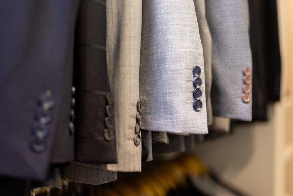 A row of men’s suit sleeves with different colors, patterns, and cuts