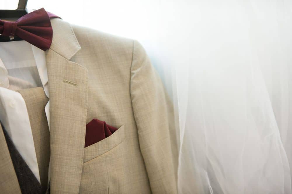 A light beige linen suit hanging on a rack, ideal fabric for hot weather