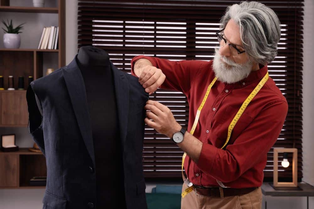 A designer stitching the interlining of a canvassed suit jacket by hand
