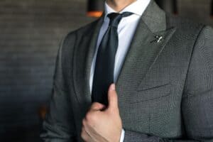 A man in a well-tailored suit. Made-to-measure suits make it easier on how to dress rich as a man.