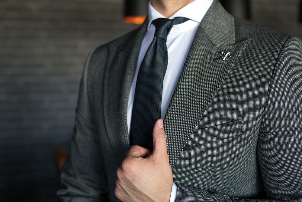 A man in a well-tailored suit. Made-to-measure suits make it easier on how to dress rich as a man.
