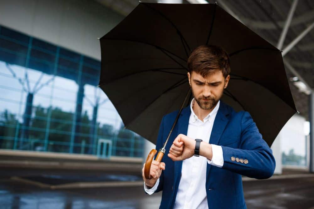 A businessman in a suit checks his watch. Good fabrics matter for Bangkok’s climate.