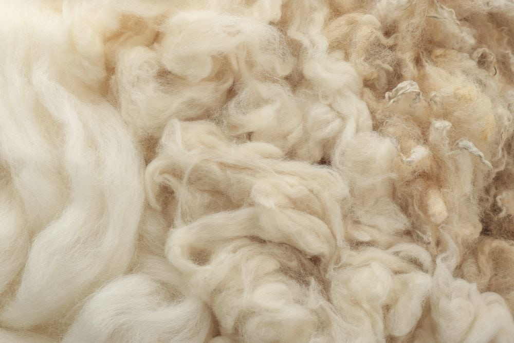 A close-up of wool fabric texture showing the fine fiber quality used in premium suit tailoring