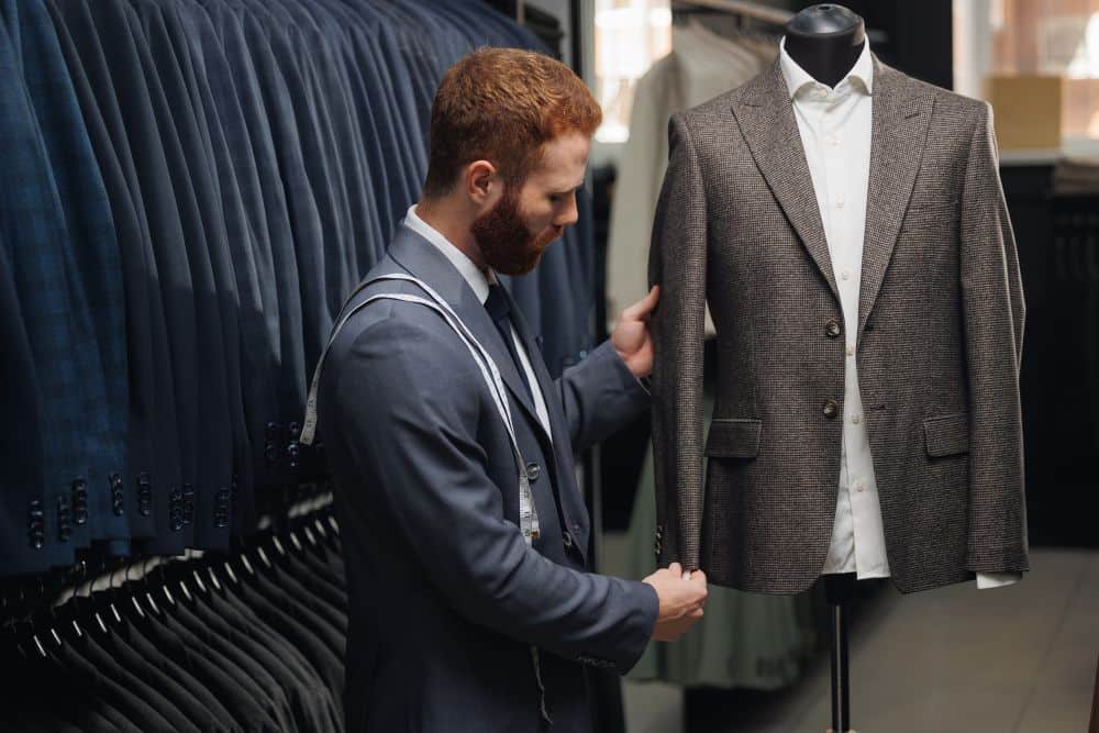 A tailor hand-checks every detail of a custom suit, proving why it is worth getting one made