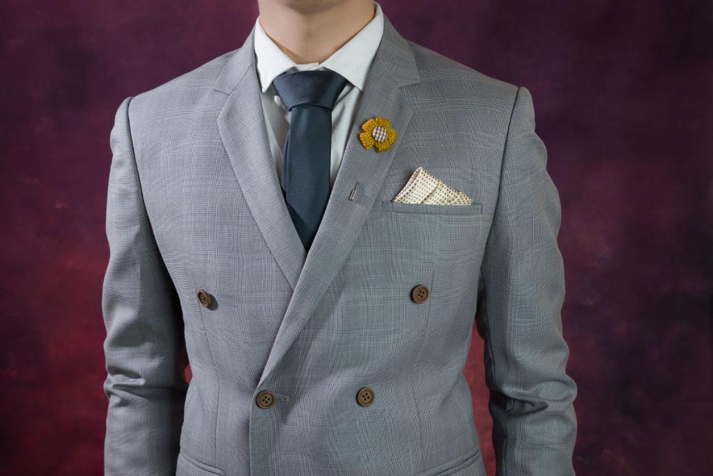A man wearing a double-breasted suit, featuring buttons showing overlapping front and peak lapel.