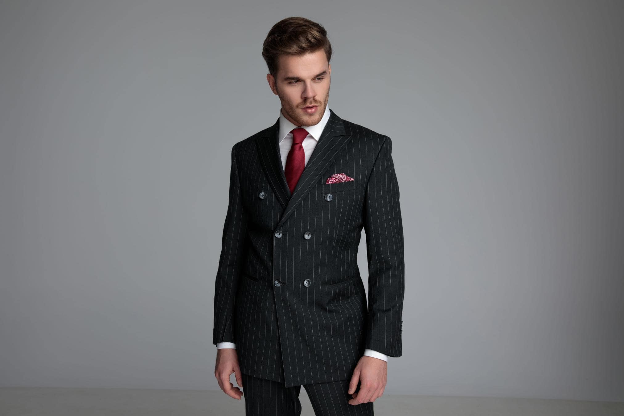 A man dressed in a double-breasted suit with peak lapels and a tailored fit